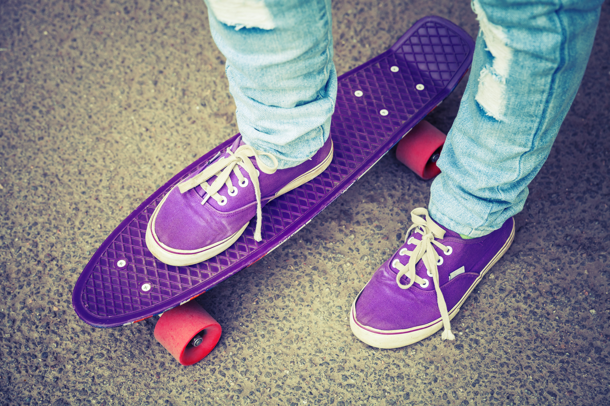 Young skateboarder in gumshoes and jeans 3 teenage girls eating popcorn.