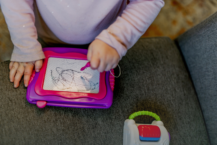 Toddler Playing with Magna Doodle Magnetic Drawing Toy