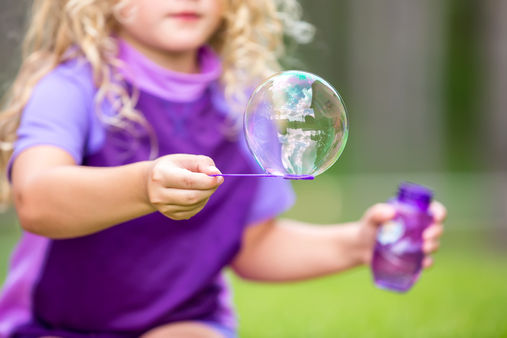 Close-Up of Girl Holding Large Bubble on Purple Wand